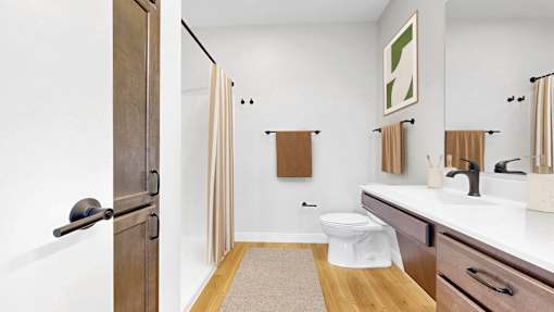 A bathroom with a toilet, sink, and shower.at The Rosalyn | Affordable 55+ Apartments in Bloomington, Bloominton