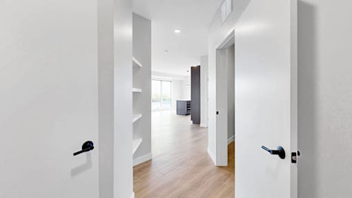 A hallway with a black door handle and a black door.