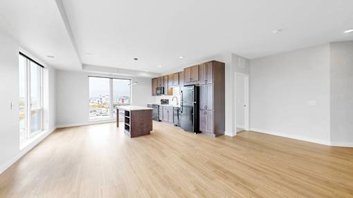 A kitchen with a refrigerator, sink, and cabinets.