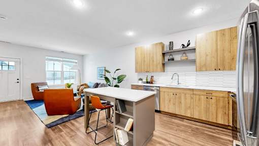 A modern kitchen with wooden cabinets and a white backsplash.