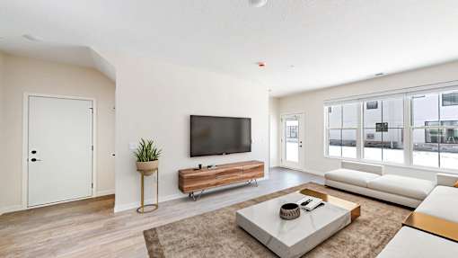 A modern living room with a flat screen TV and a white sofa.