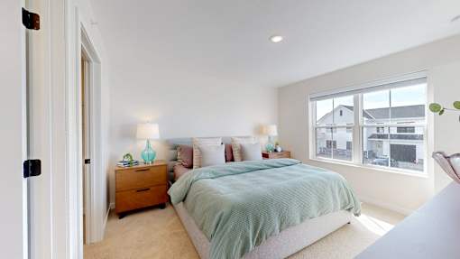 A bedroom with a bed, nightstand, and lamp.