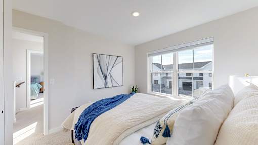 A bedroom with a large bed and a window overlooking a building.