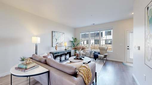 A living room with a couch, a table, and a lamp.