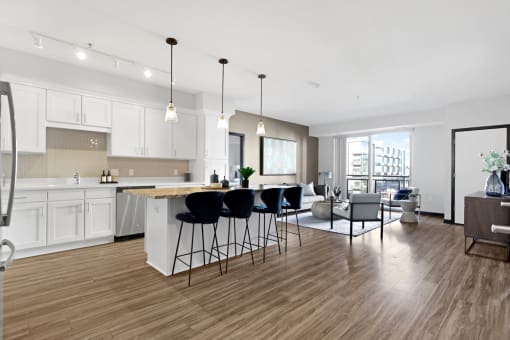 an open kitchen and living room with an island and bar stools