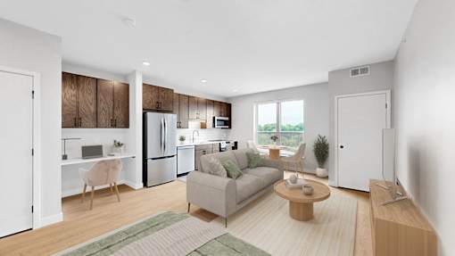 A modern living room with a couch, coffee table, and kitchen area.