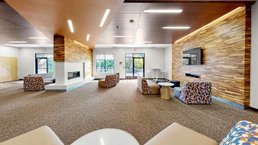 A spacious room with a stone wall and a fireplace.