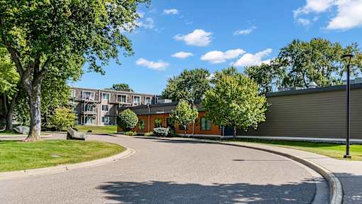 A sunny day at a residential area with a curved road and houses.