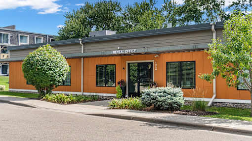 A rental office building with a green lawn in front.
