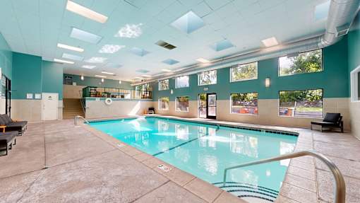 A large indoor swimming pool with a glass enclosure.