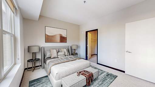 A bedroom with a large bed and a painting on the wall.