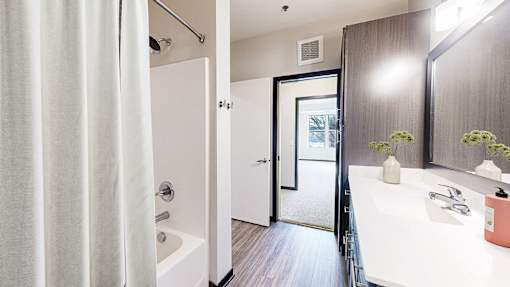 A bathroom with a white tub and sink.