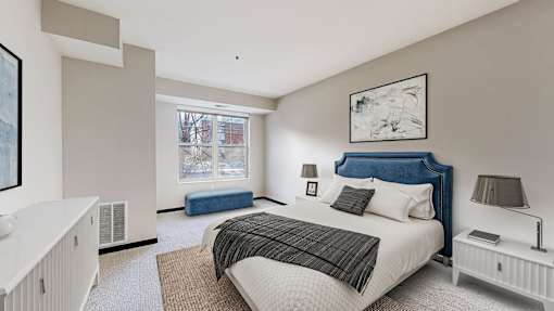 A bedroom with a large bed and a window seat.