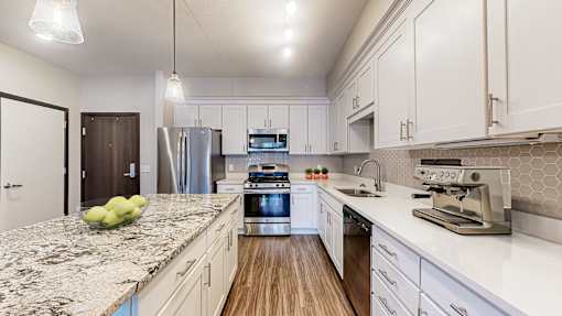 A kitchen with granite countertops and stainless steel appliances.