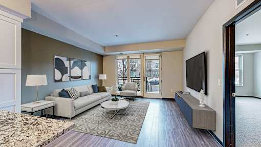 A living room with a couch, a coffee table, and a television.