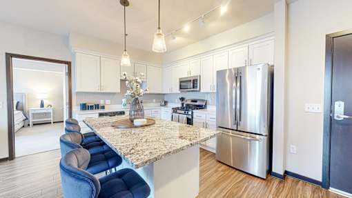 A kitchen with a marble countertop and stainless steel appliances.