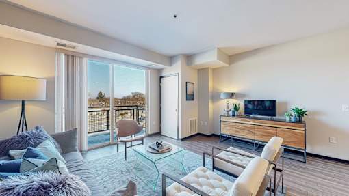 A modern living room with a glass coffee table and a flat screen TV.