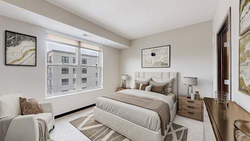 A bedroom with a large bed and a chair.