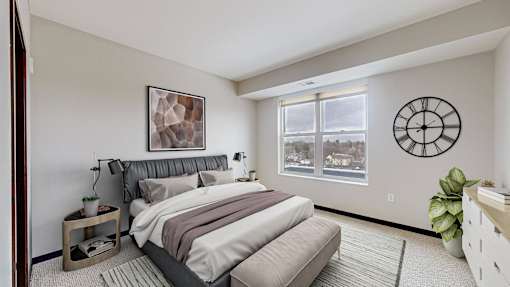 A bedroom with a large bed and a window overlooking a snowy landscape.