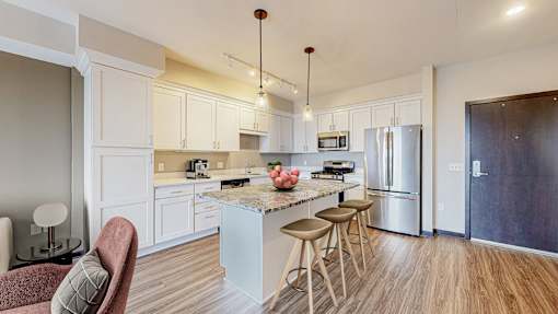 A kitchen with a white island and stools.