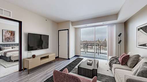 A modern living room with a large window overlooking a balcony.