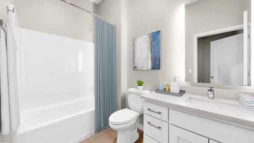 A white bathroom with a toilet, sink, and shower.