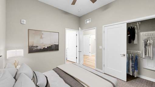 A bedroom with a large bed and a wardrobe with clothes hanging in it.