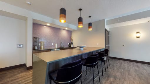 a kitchen with a long counter and a row of black chairs at The Morrison, Minnesota