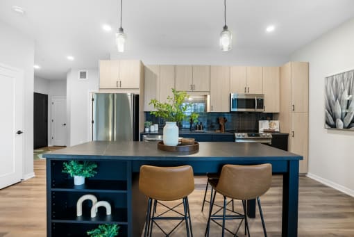 a kitchen with a blue island and three stools