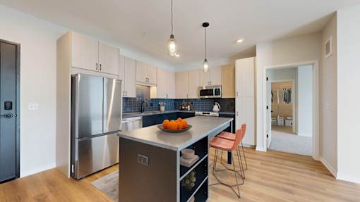 A kitchen with a refrigerator, sink, and countertop.
