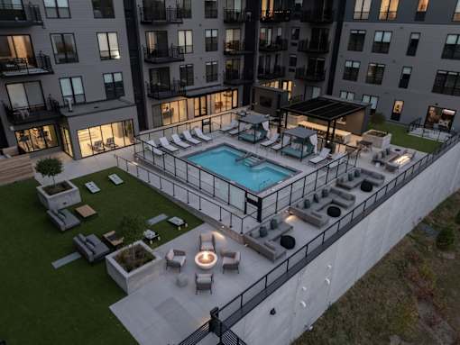 A large outdoor pool surrounded by lounge chairs and umbrellas.