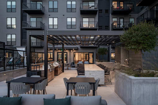 A modern outdoor patio area with a table and chairs.