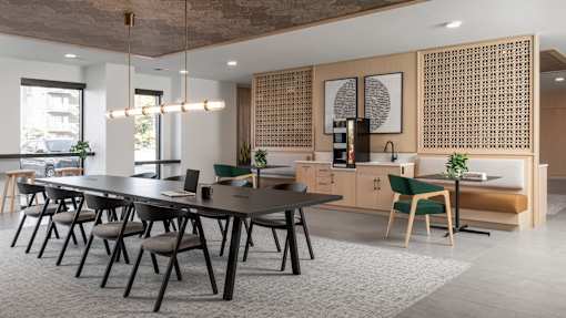 A modern dining area with a long table and chairs.