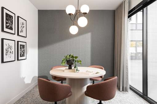 A modern dining room with a round table and chairs.
