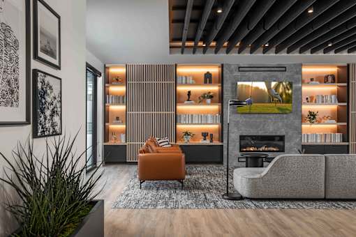 A modern living room with a fireplace and a grey sofa.