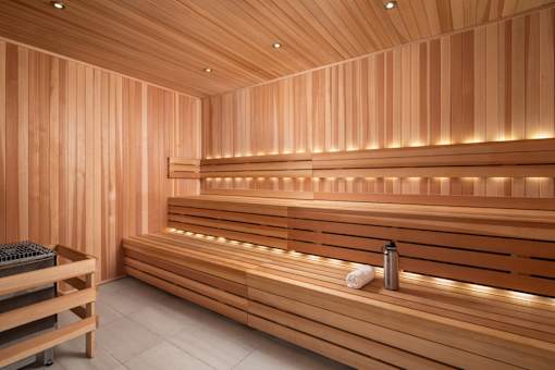 A wooden sauna with benches and lights.