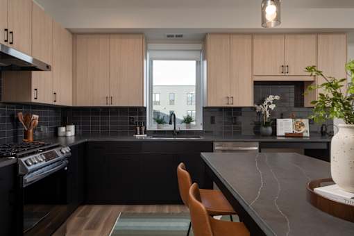 A kitchen with black countertops and wooden cabinets.