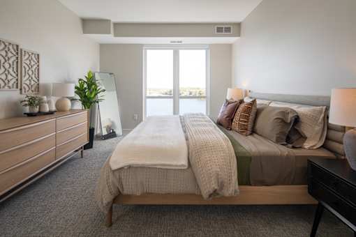 A bedroom with a large bed and a dresser with a mirror.