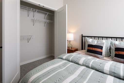 A bedroom with a bed, pillows, and a lamp.