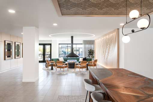 A modern living room with a large wooden table and a curved sofa.