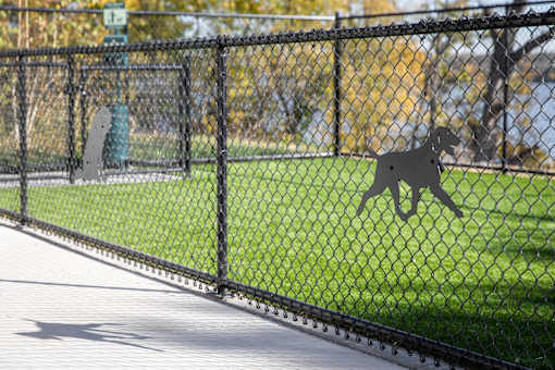 A dog silhouette is on the fence.