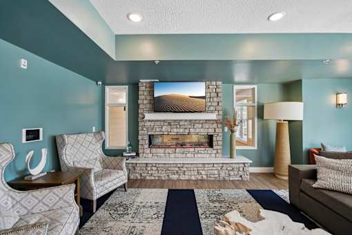 A living room with a fireplace and a painting on the wall.