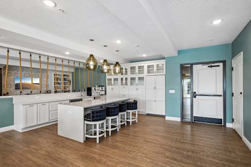 A kitchen with white cabinets and a blue wall.