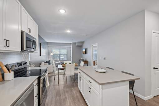 A modern kitchen with white cabinets and stainless steel appliances.