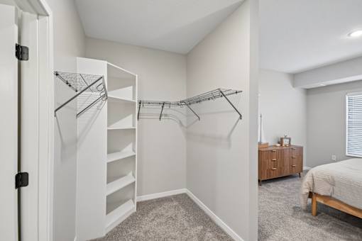A bedroom with a bed, dresser, and a staircase.