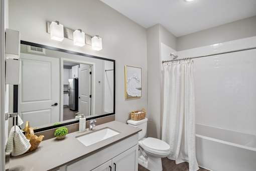 A white bathroom with a sink, toilet, and bathtub.