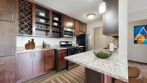 A kitchen with a granite countertop and wooden cabinets.