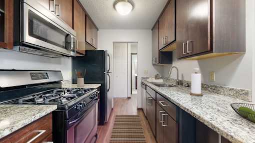 A kitchen with a black stove top oven and a black refrigerator.