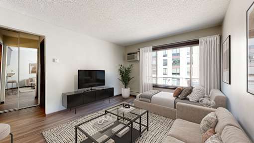 A modern living room with a flat screen TV and a glass coffee table.