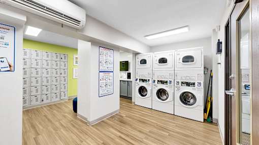 A laundromat with a row of washers and dryers.